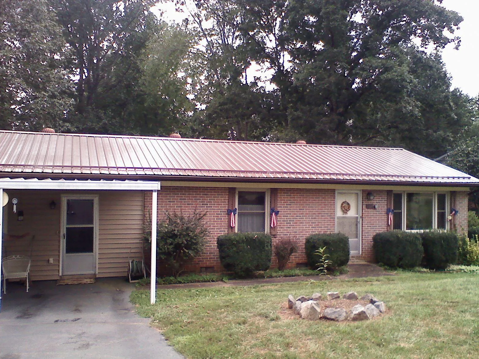 Bronze metal roof and carport on a brick ranch home — Roof Repair work by our crew in Kinards